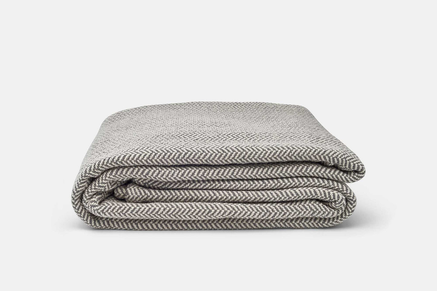 Folded herringbone weave cotton blanket in neutral tones