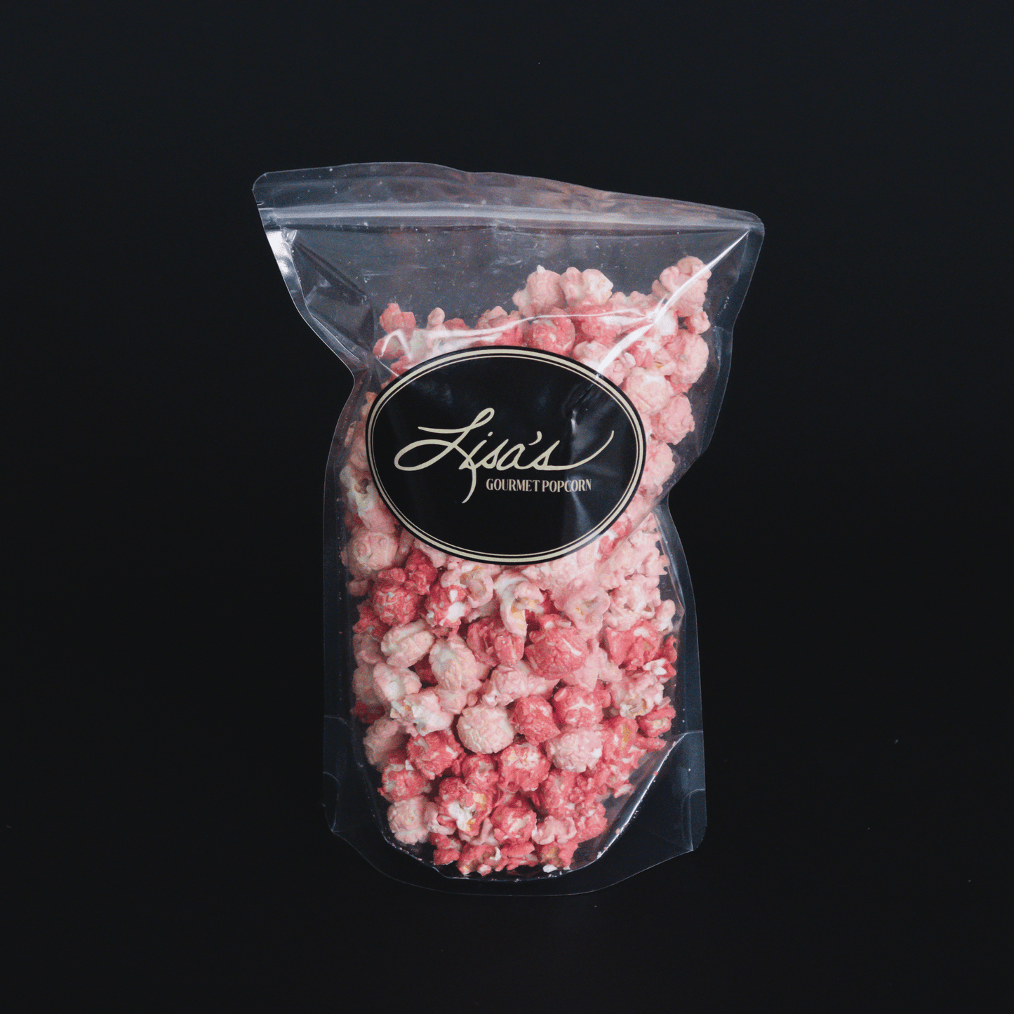 Raspberry Dream Popcorn bag with white chocolate and raspberry flavored gourmet popcorn on black background