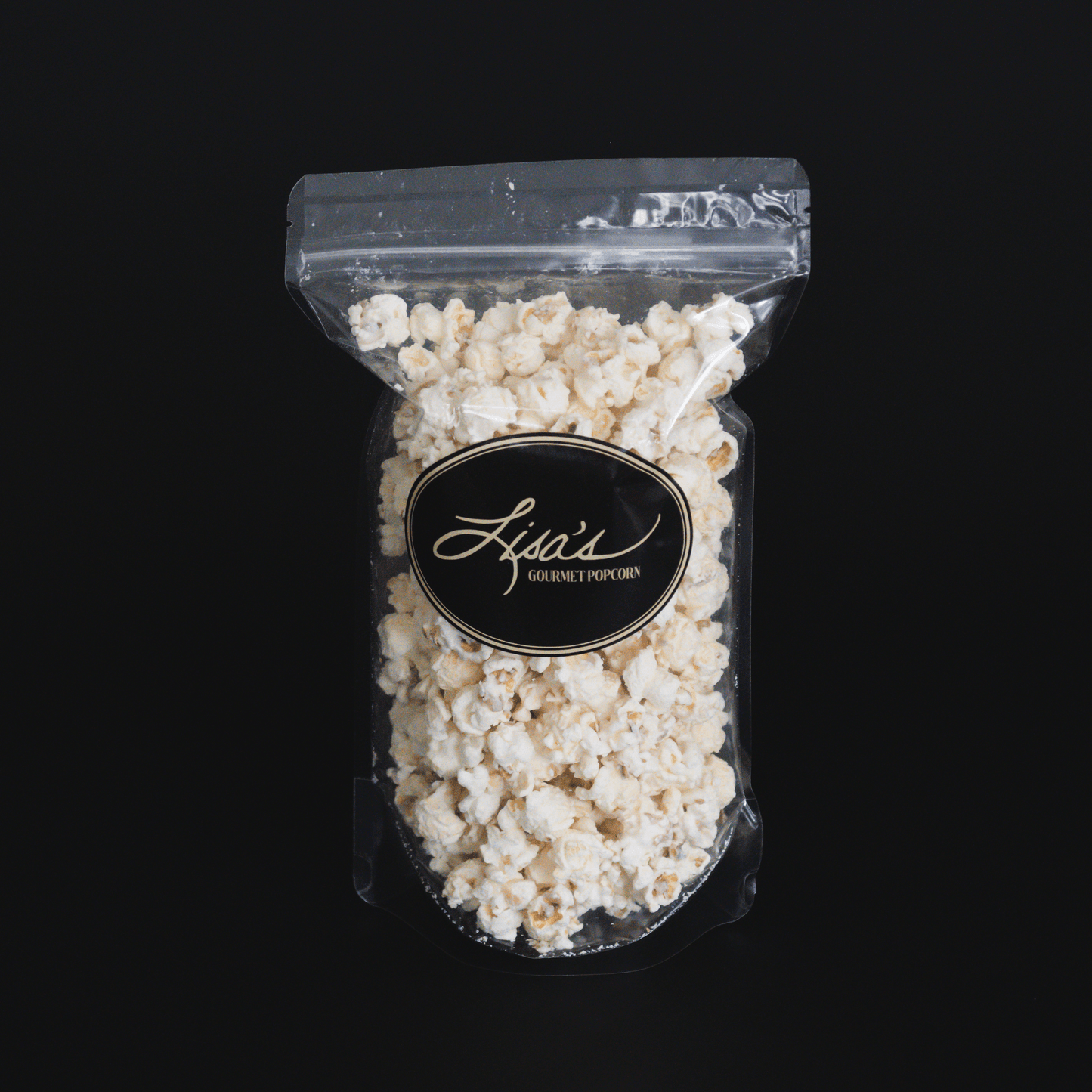 Clear resealable bag of gourmet white chocolate popcorn on black background