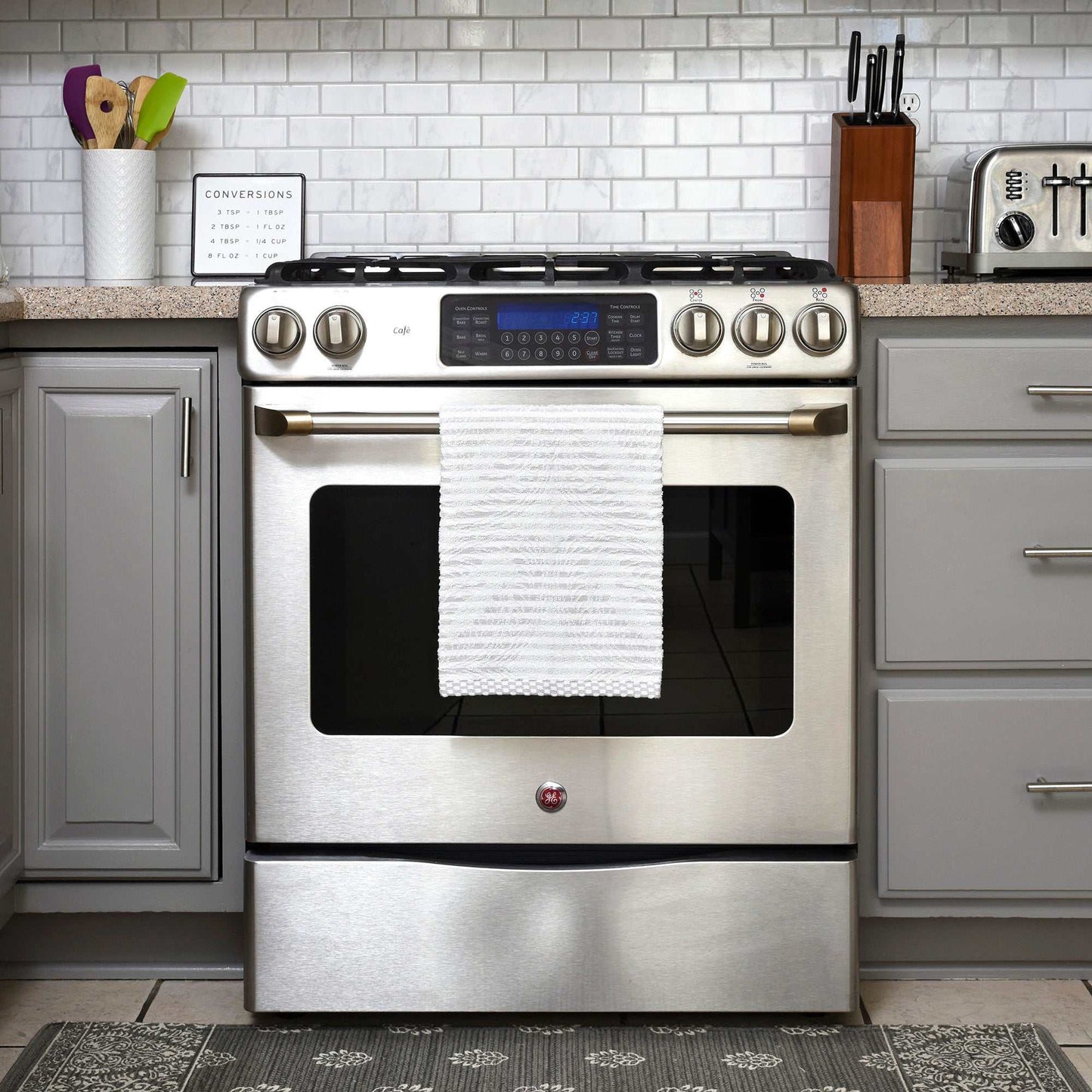 organic cotton kitchen towel hanging on stainless steel oven in modern kitchen