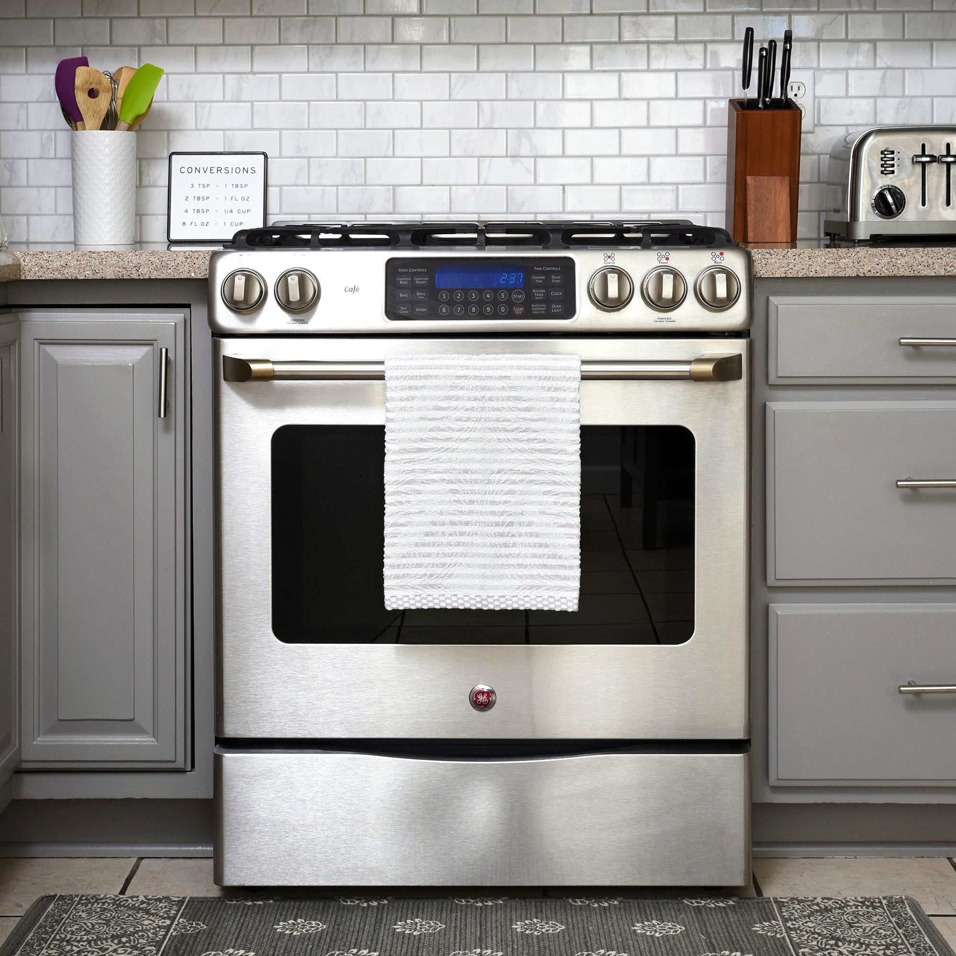 organic cotton kitchen towel hanging on stainless steel oven in modern kitchen
