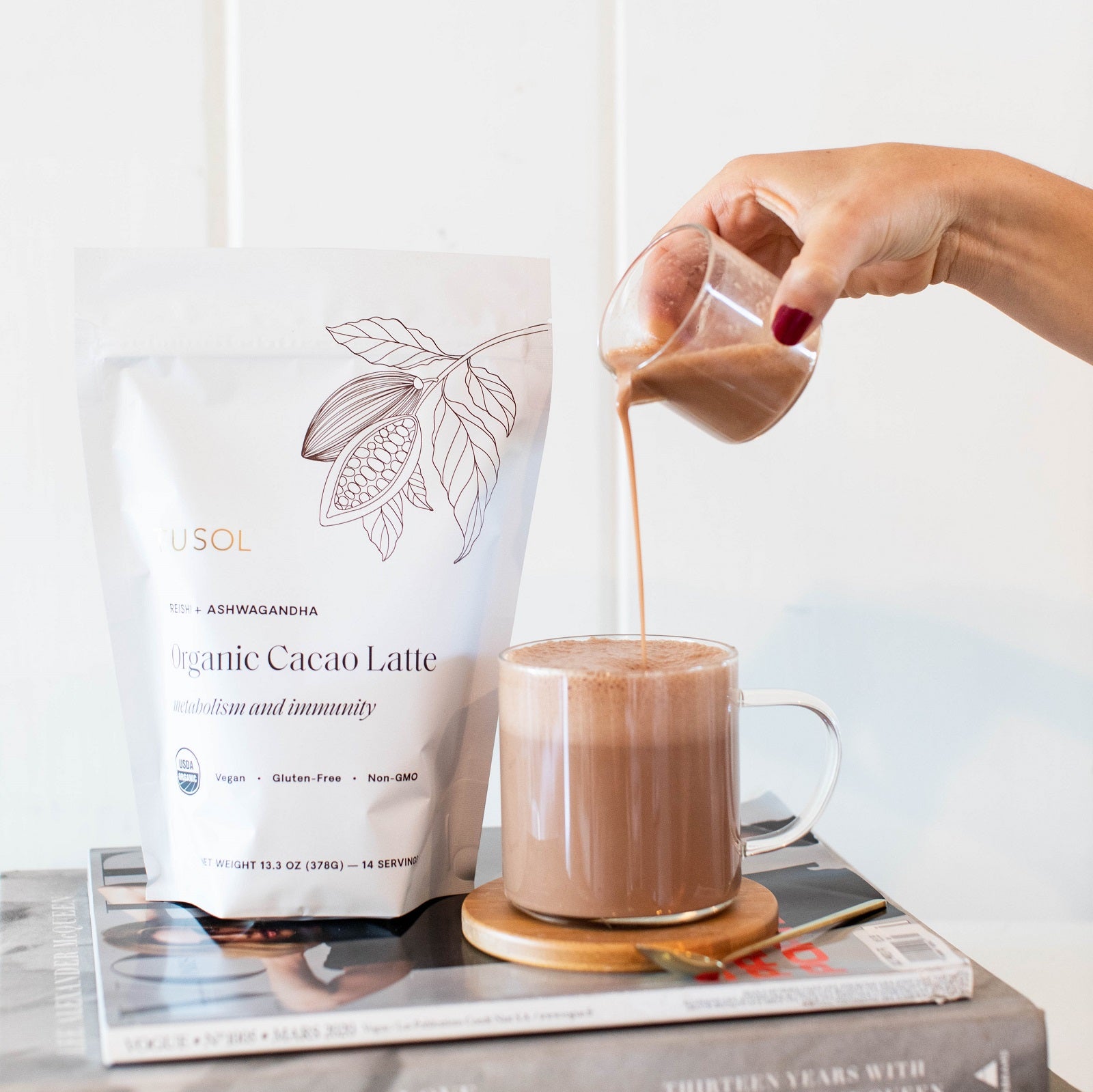TUSOL Full Body Reset Organic Cacao Latte being poured into a glass mug, showcasing superfood-rich, metabolism and immunity boosting organic drink.
