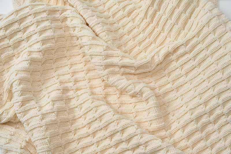 Soft cotton knitted baby blanket with textured pattern for crib and stroller use