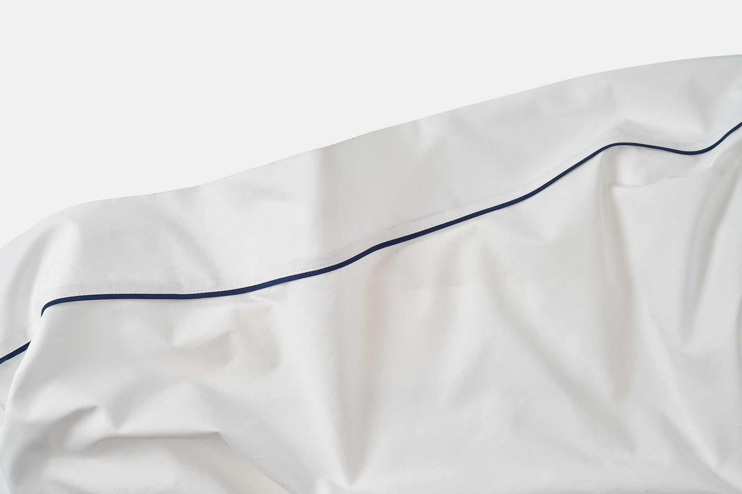 White cotton bed sheet with blue piping design detail