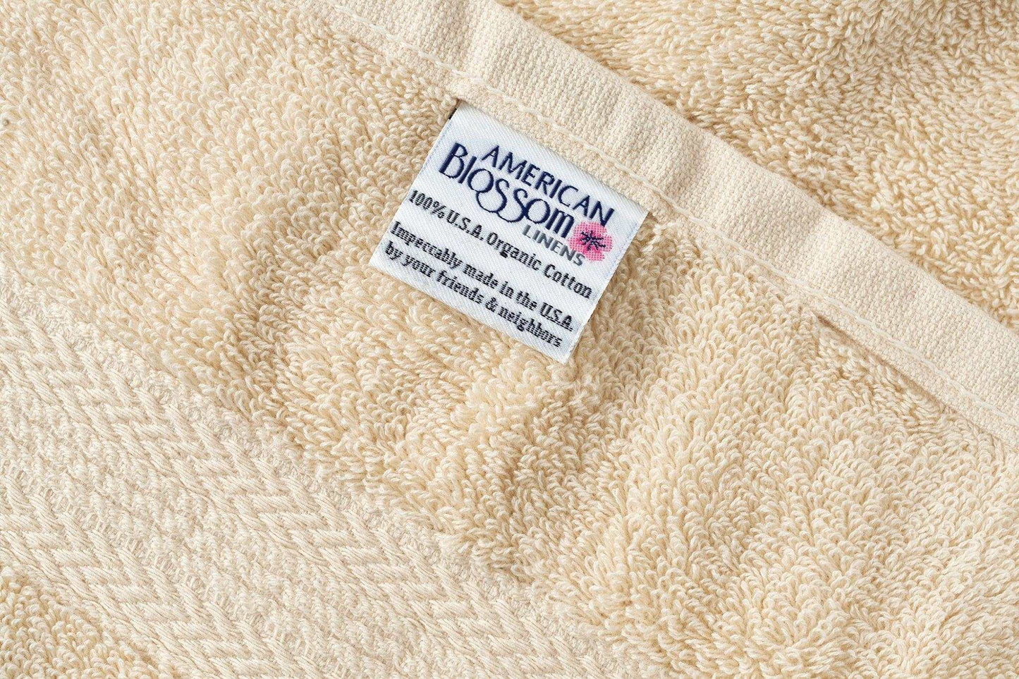 Close-up of premium USA cotton bathroom washcloth with label showing organic and American craftsmanship