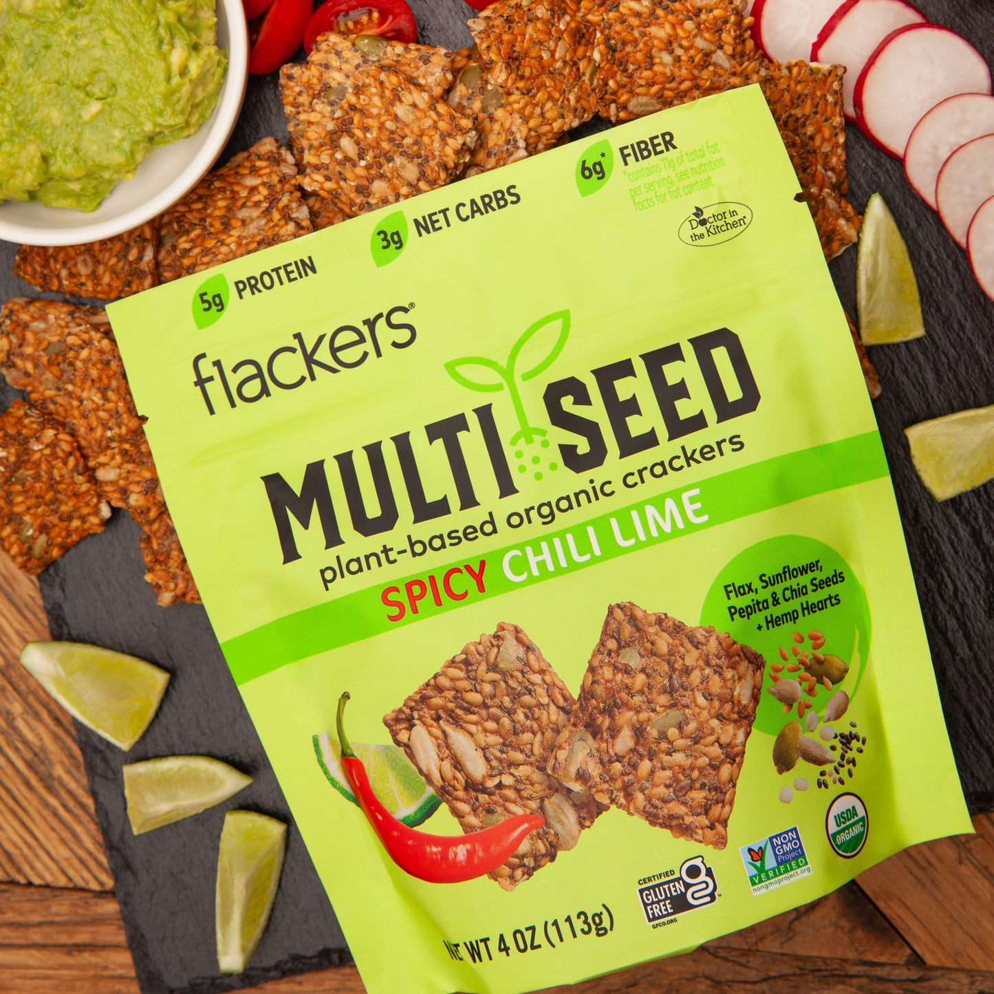 Spicy Chili Lime Multi Seed Crackers package with organic vegan seed crackers and lime wedges on slate board