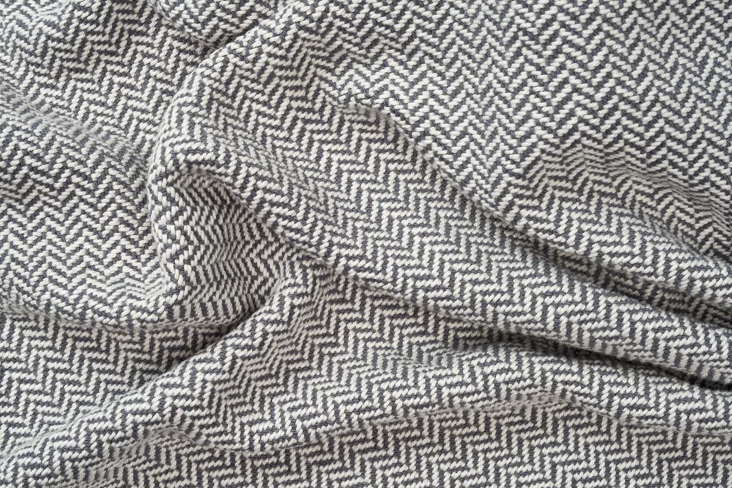 Soft herringbone weave cotton blanket with grey and white pattern, cozy and perfect weight for year-round use
