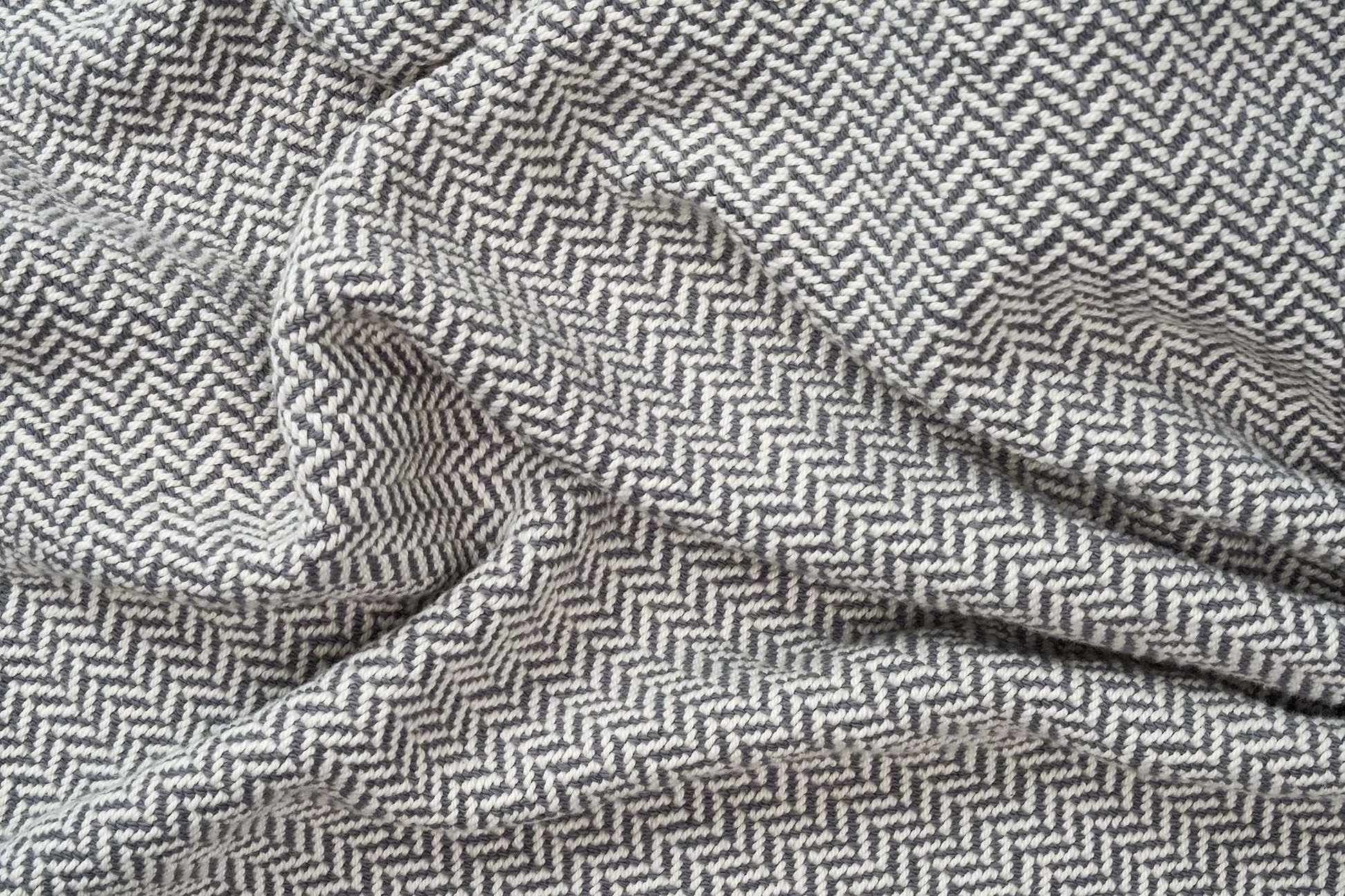 Soft herringbone weave cotton blanket with grey and white pattern, cozy and perfect weight for year-round use