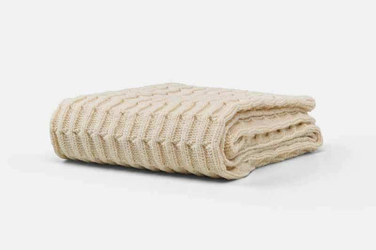 Folded cotton knitted baby blanket with textured pattern for crib or stroller use