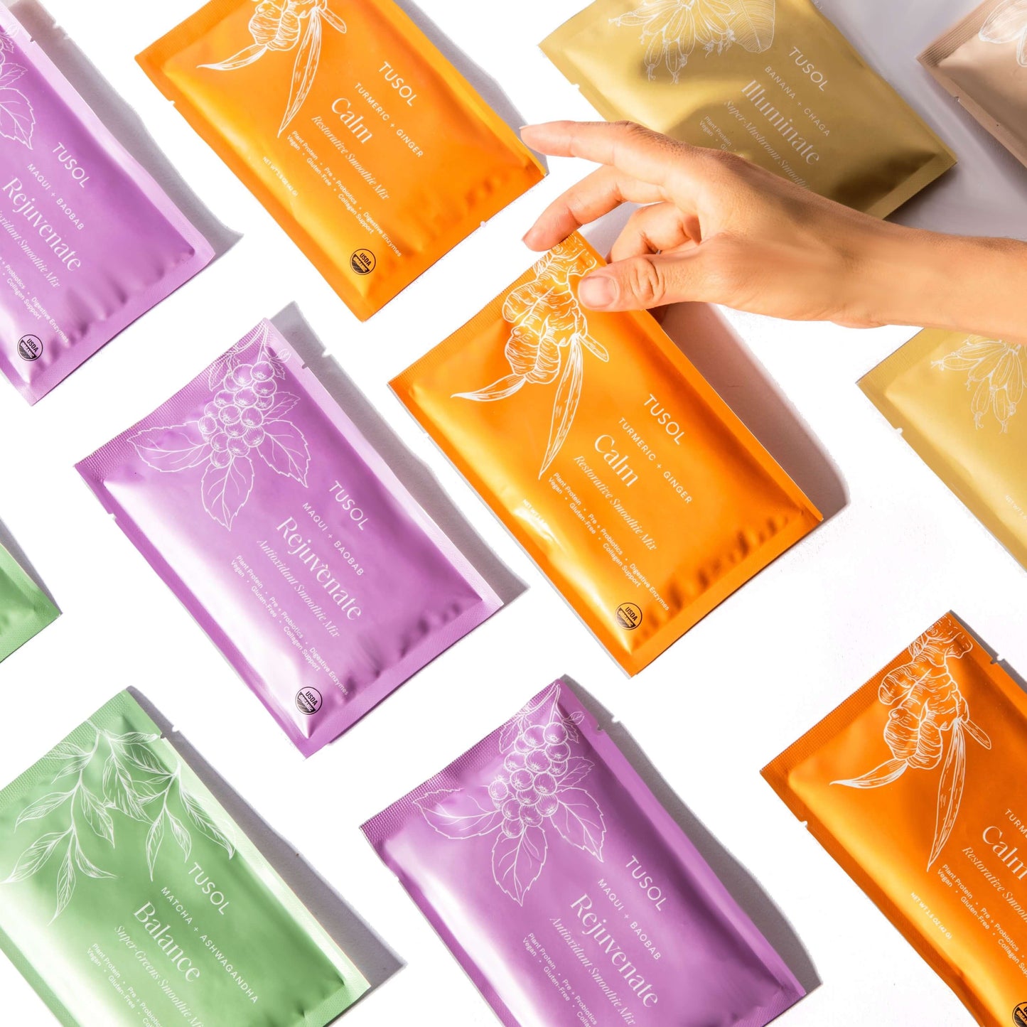 TUSOL Full Body Reset Kit colorful superfood supplement packets with hand holding orange Calm packet