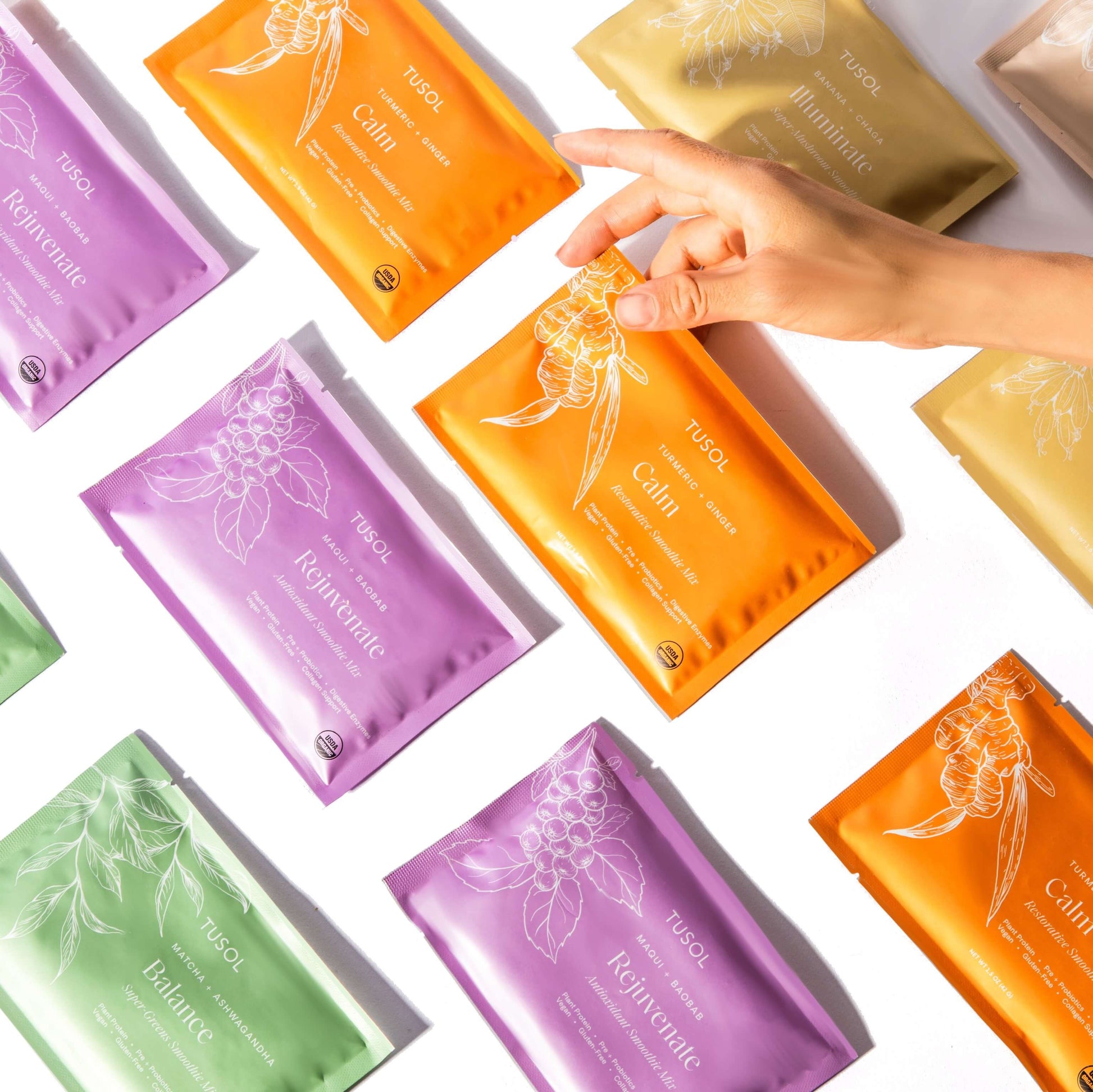 TUSOL Full Body Reset Kit colorful superfood supplement packets with hand holding orange Calm packet