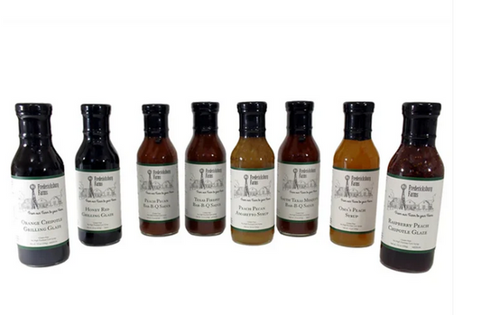 Set of grilling and syrup bottles including glazes and BBQ sauces in a bundle basket