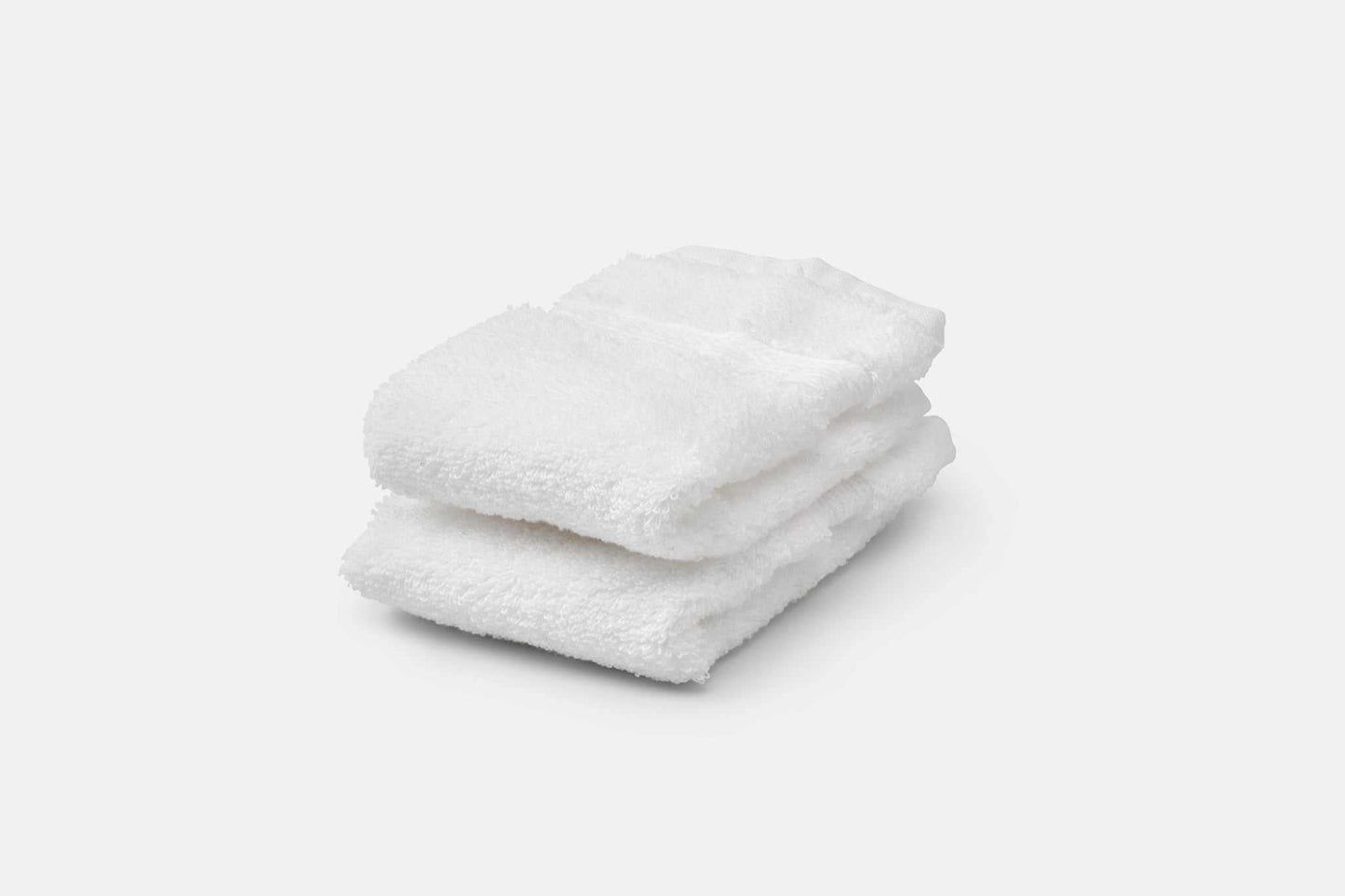 Stack of white luxury USA cotton bathroom washcloths with 700 GSM softness and absorbency