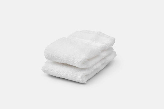 Stack of white luxury USA cotton bathroom washcloths with 700 GSM softness and absorbency