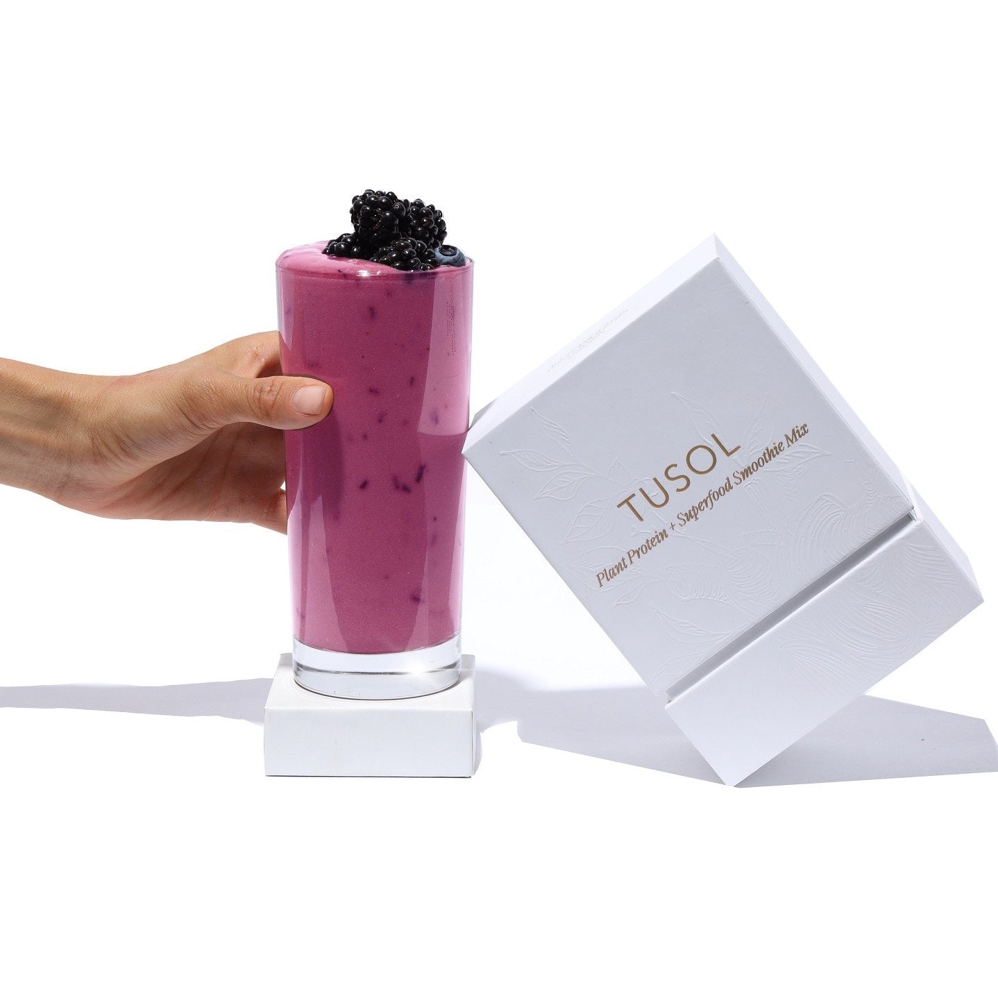 Plant Protein + Superfood Smoothie Mix sample box with purple smoothie and berries on top