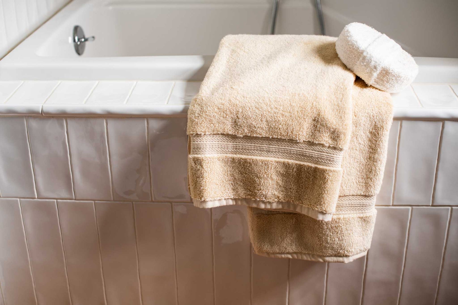 Luxury USA cotton bath towel with 700 GSM softness and absorbency on a white tiled bathtub