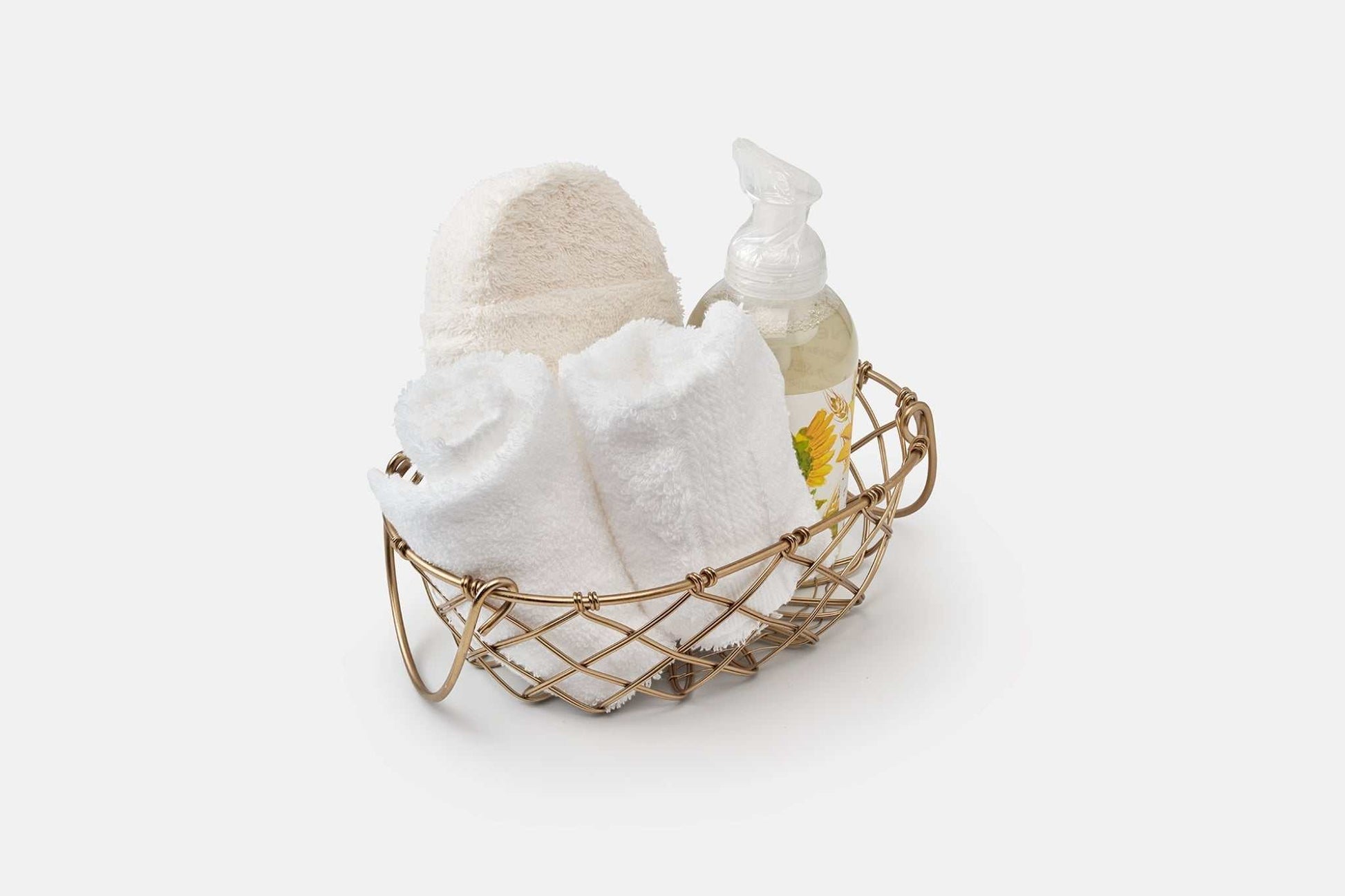 Bathroom washcloths made of luxury USA cotton rolled and displayed in a basket with lotion bottle