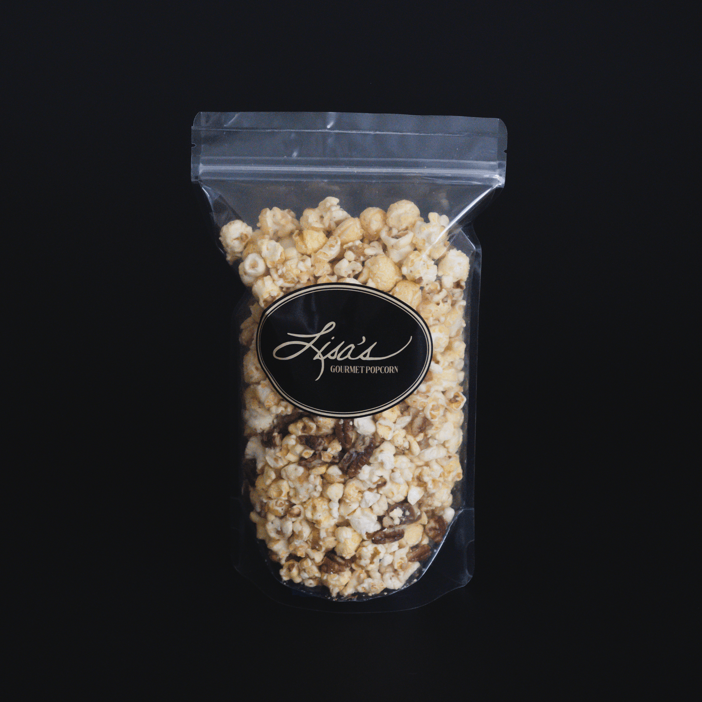 Clear resealable bag of butter pecan popcorn with crunchy pecans and buttery coating on black background