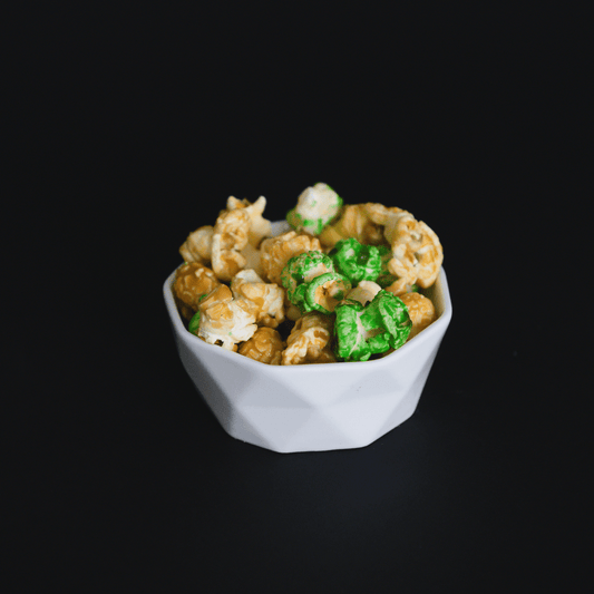 Caramel apple popcorn mix with caramel and green apple flavored popcorn in white bowl