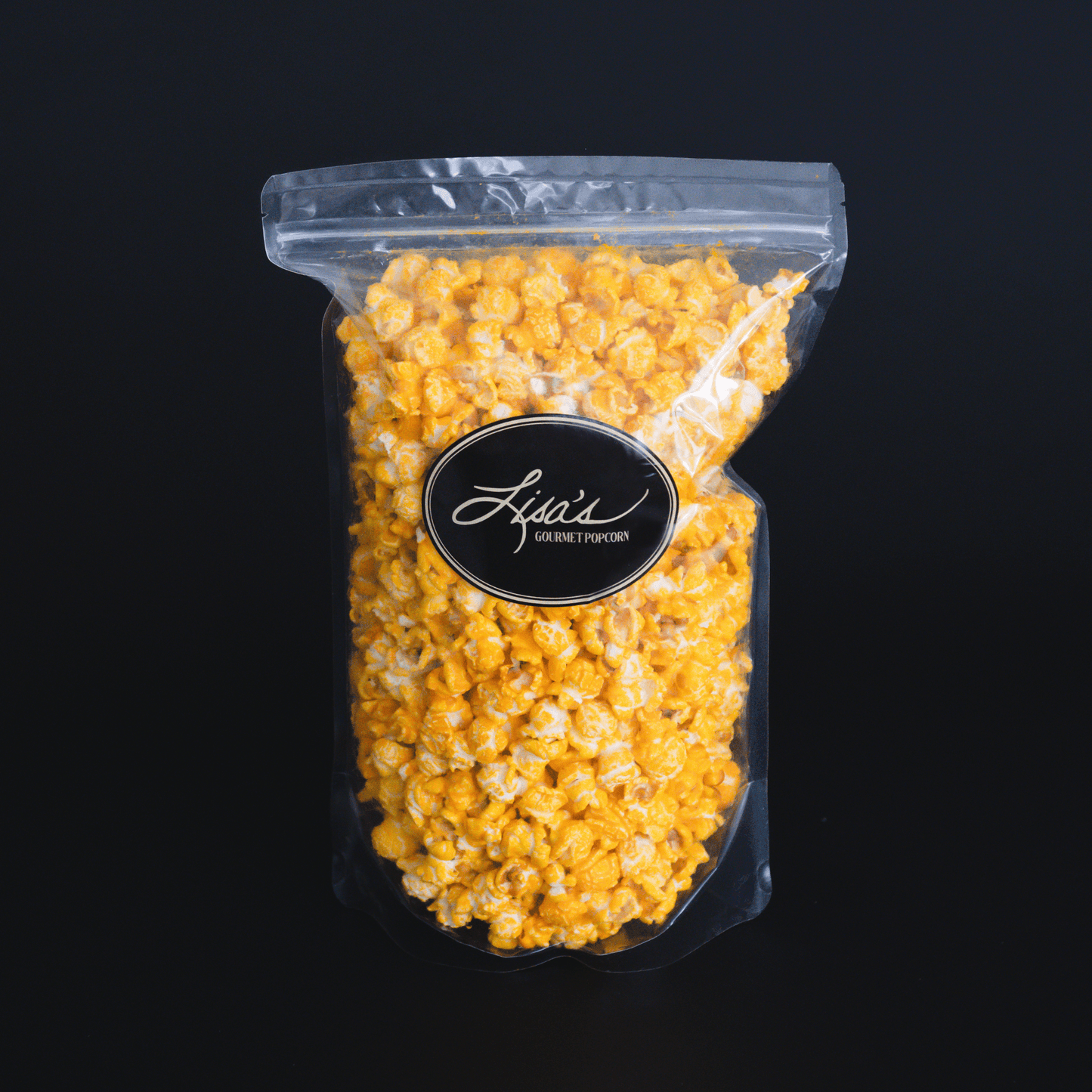 Bag of cheddar cheese popcorn with vibrant orange cheese coating against a black background