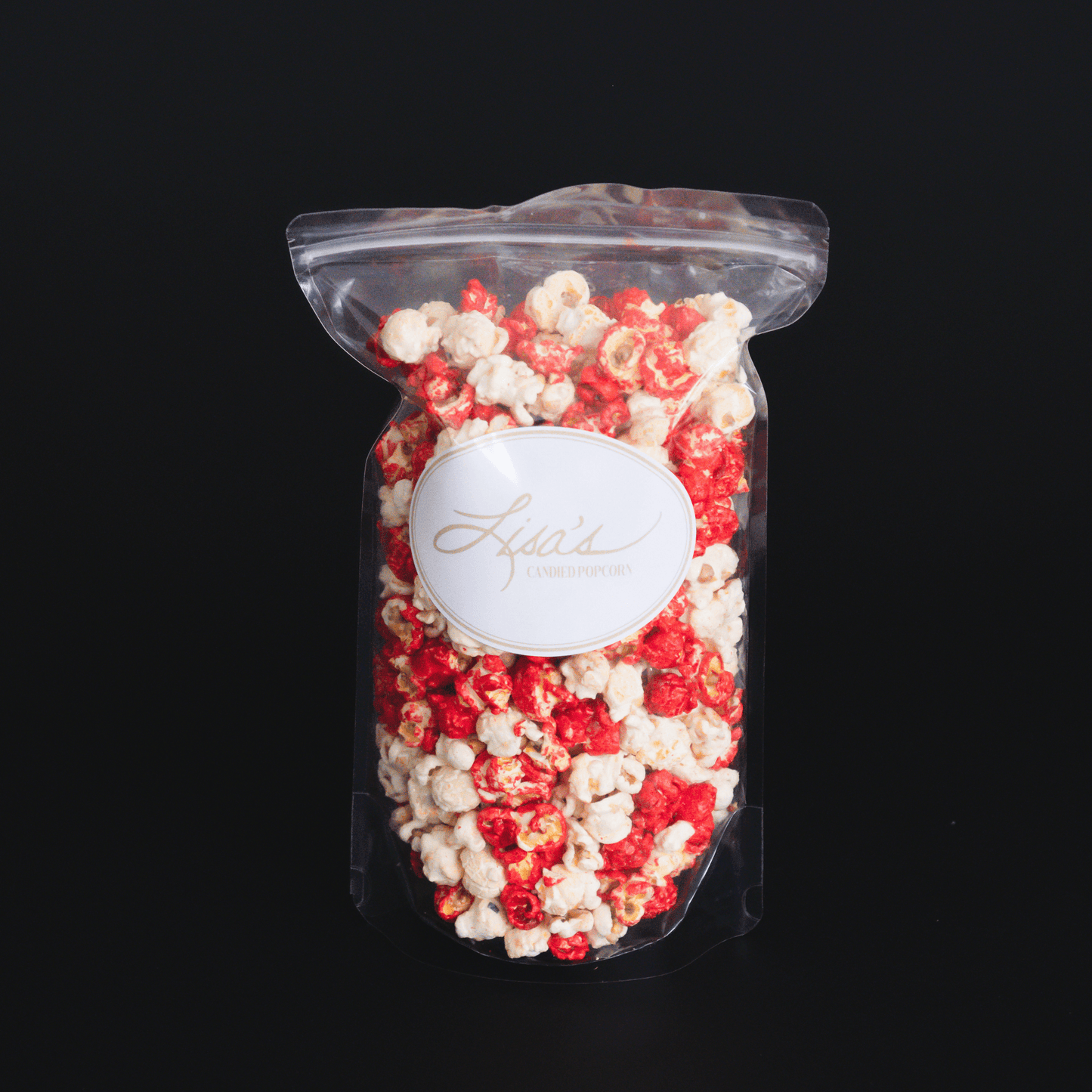 Clear resealable bag of sweet and spicy cinnamon popcorn with red cinnamon glaze