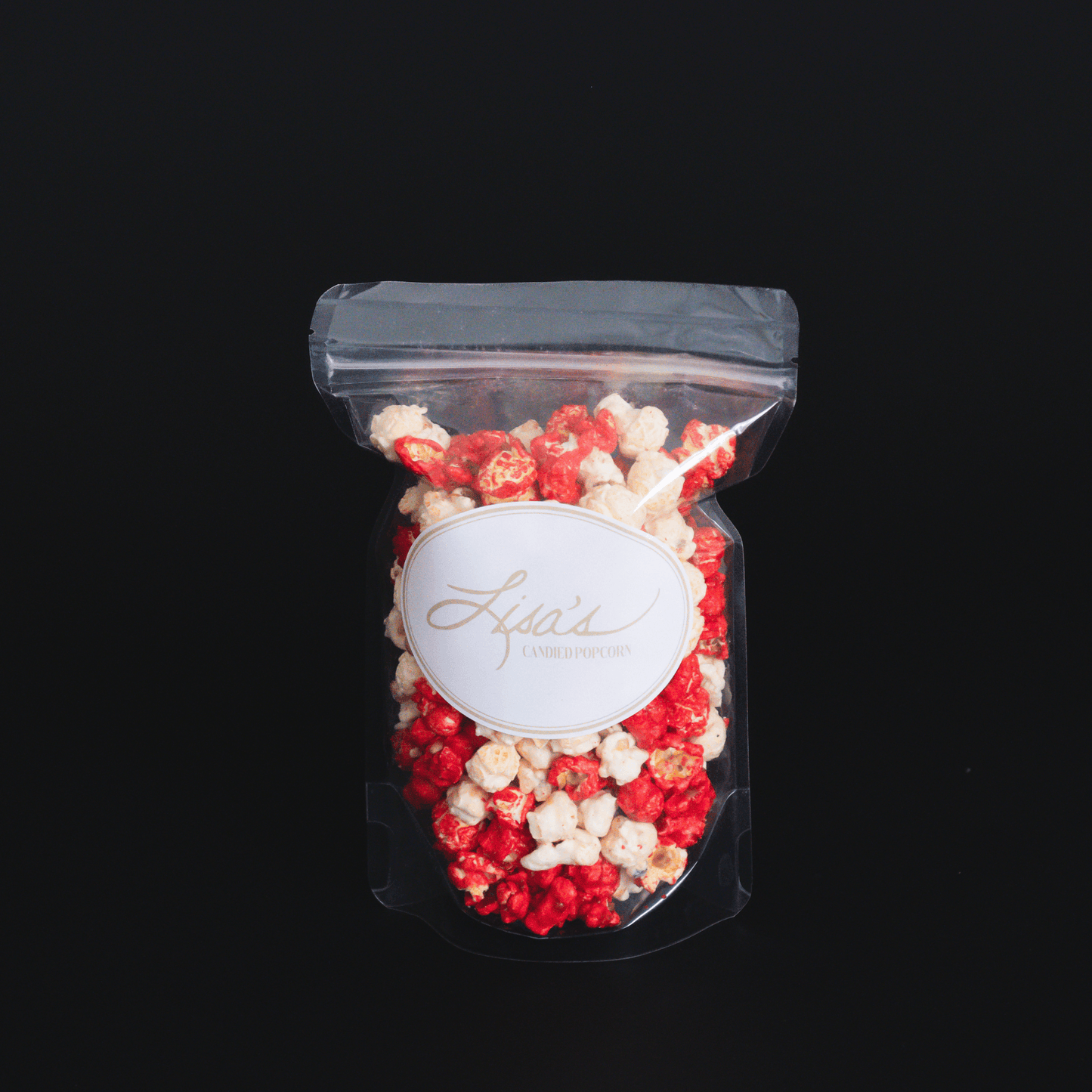 Bag of sweet and spicy cinnamon popcorn with red and white glaze on black background
