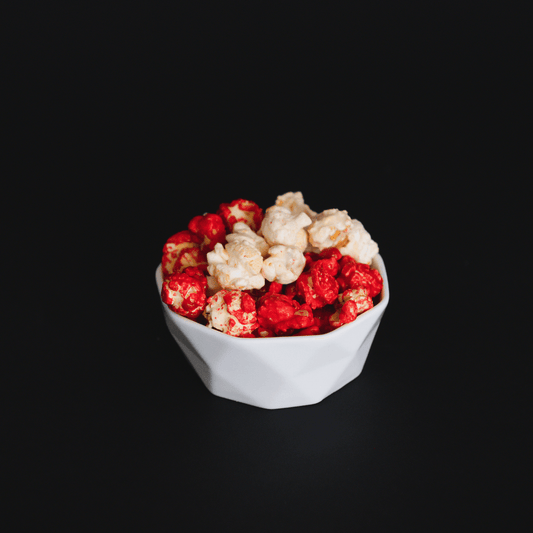 bowl of sweet and spicy candied cinnamon popcorn on black background