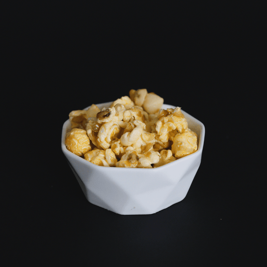 bowl of Coconut and Macadamia Nut Popcorn snack with candied coconut and crunchy macadamia nuts