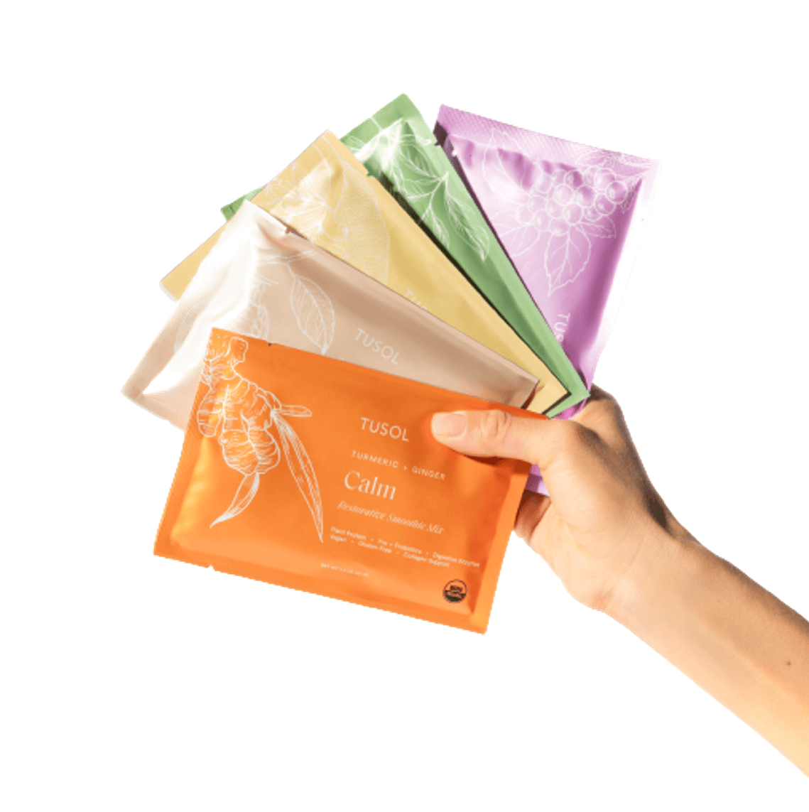 Hand holding colorful plant protein and superfood smoothie mix sample packets