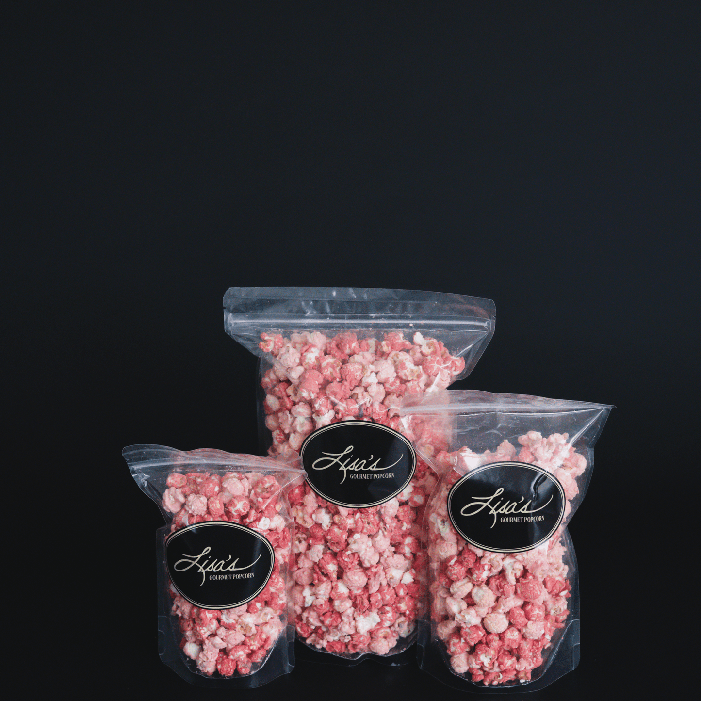 Resealable bags of pink and white Raspberry Dream Popcorn with gourmet labels