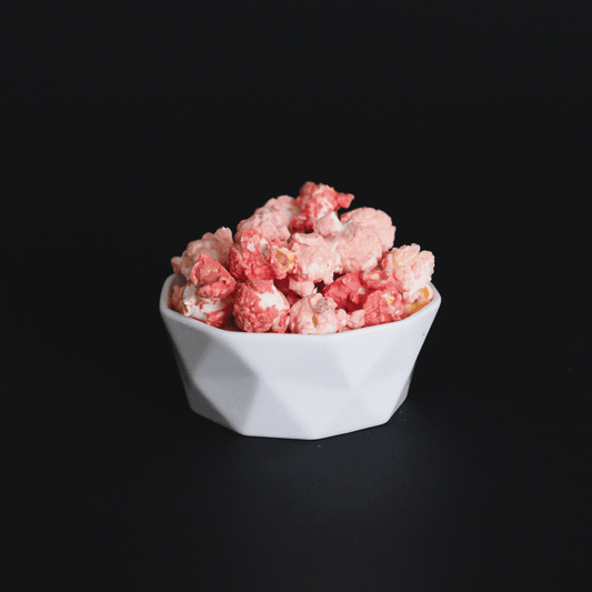 Bowl of Raspberry Dream Popcorn with white chocolate and raspberry flavor on black background