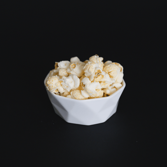 bowl of white cheddar popcorn snack on black background